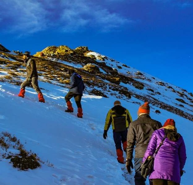 Trekkers climbing the Kedarkantha Peak